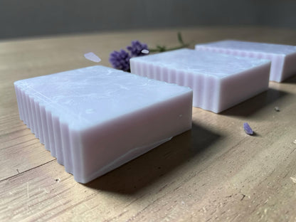 La Neve Soap and Beauty Care lavender botanical bar soap with a fluted edge design on a wooden surface